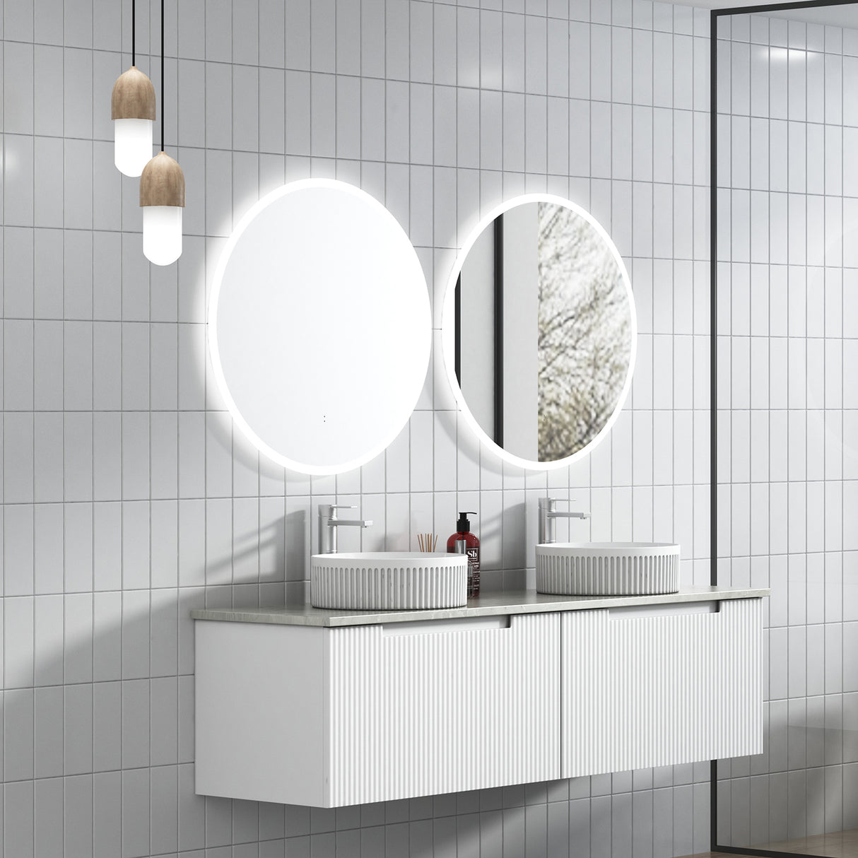 Bathroom vanity with round illuminated mirrors and white tiled walls.