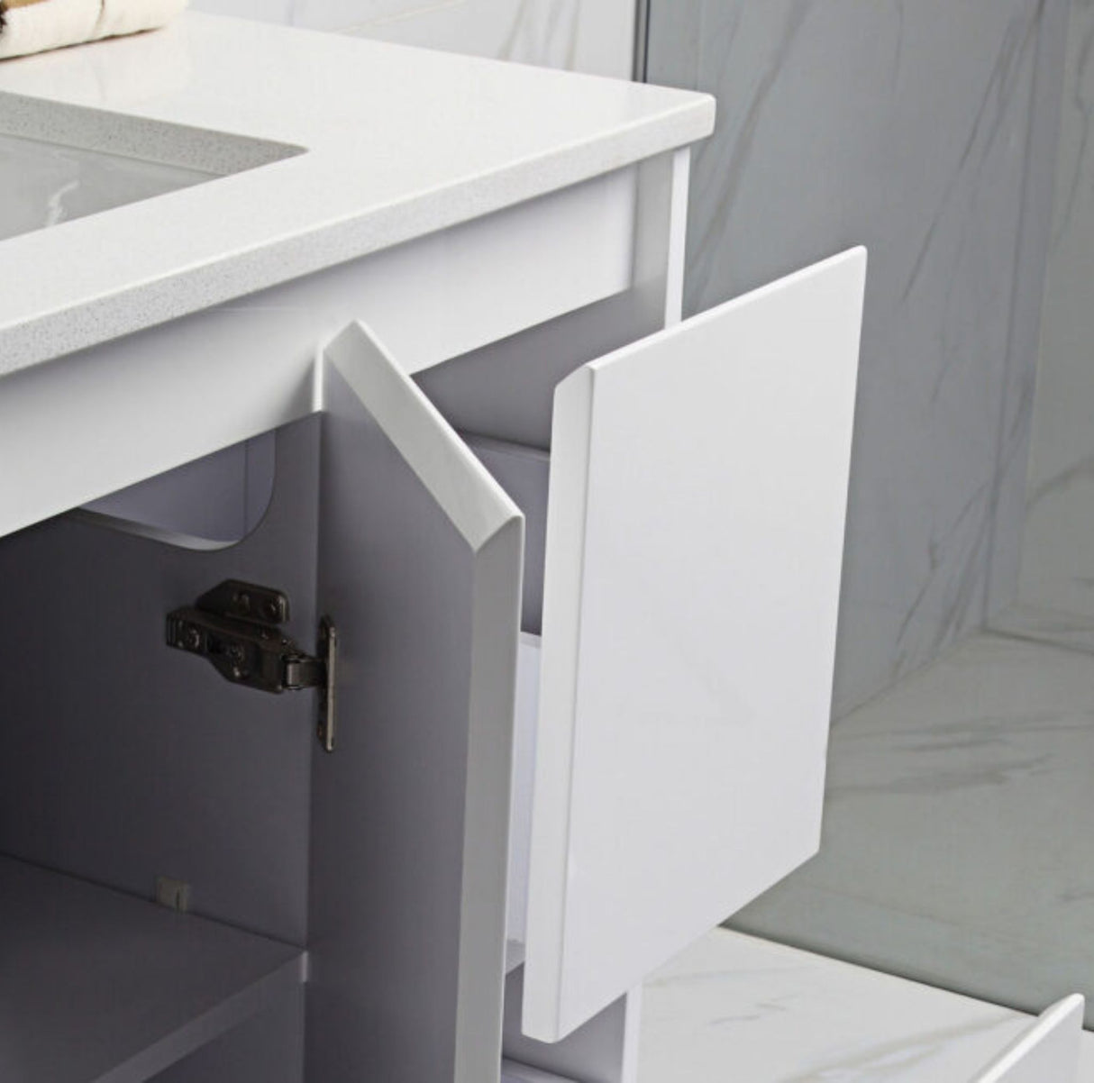 Close-up of a kitchen cabinet with an open door and a white countertop.