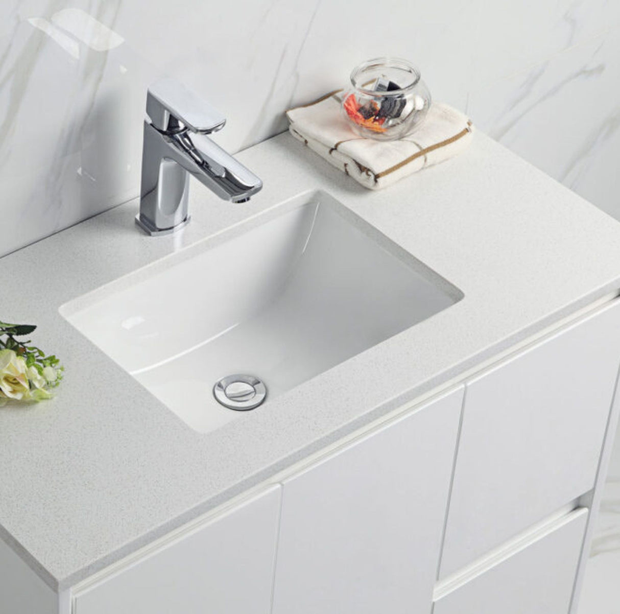 White undermount sink with chrome faucet on a white countertop