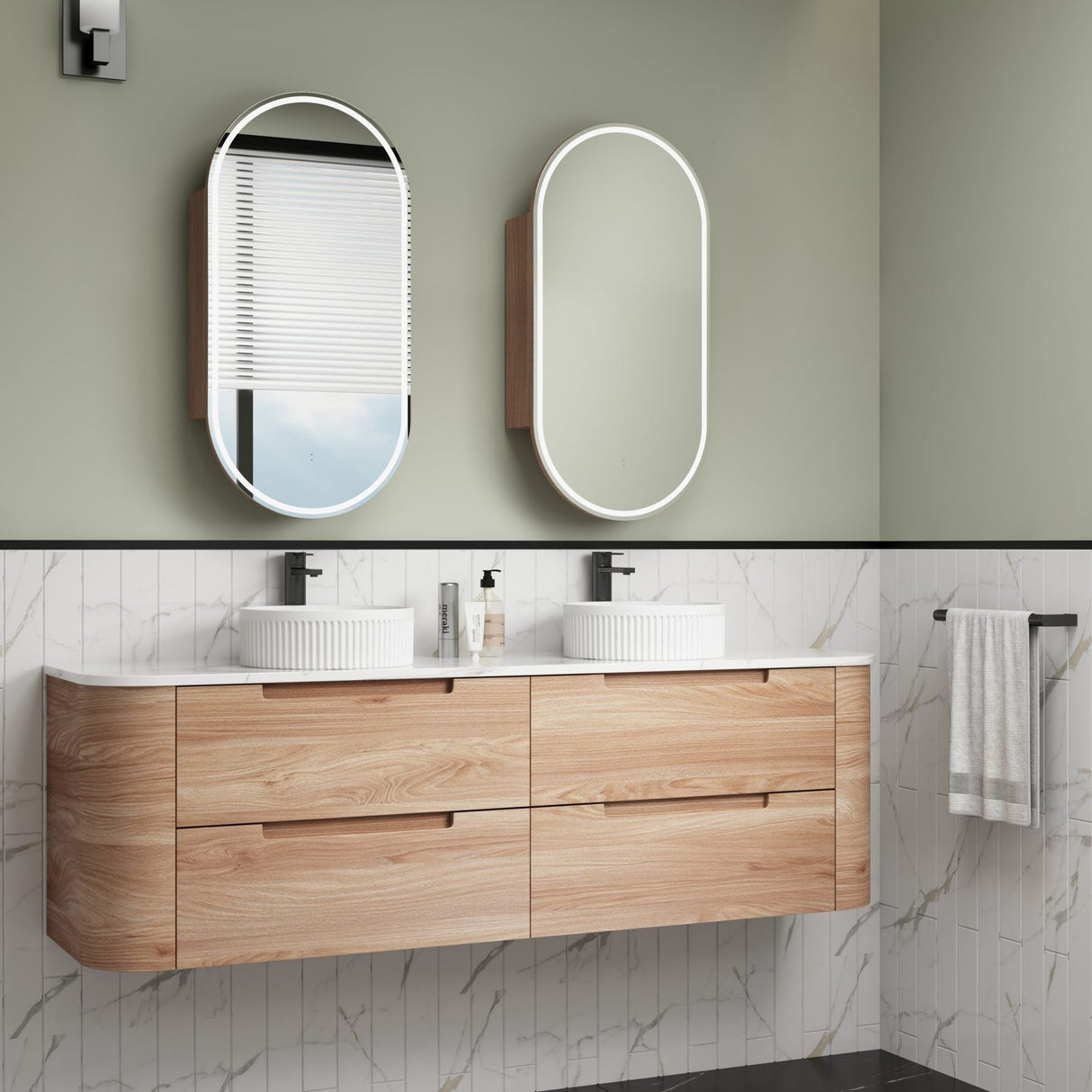 Bathroom vanity with wooden cabinets, white countertop, and mirrors on a green wall.