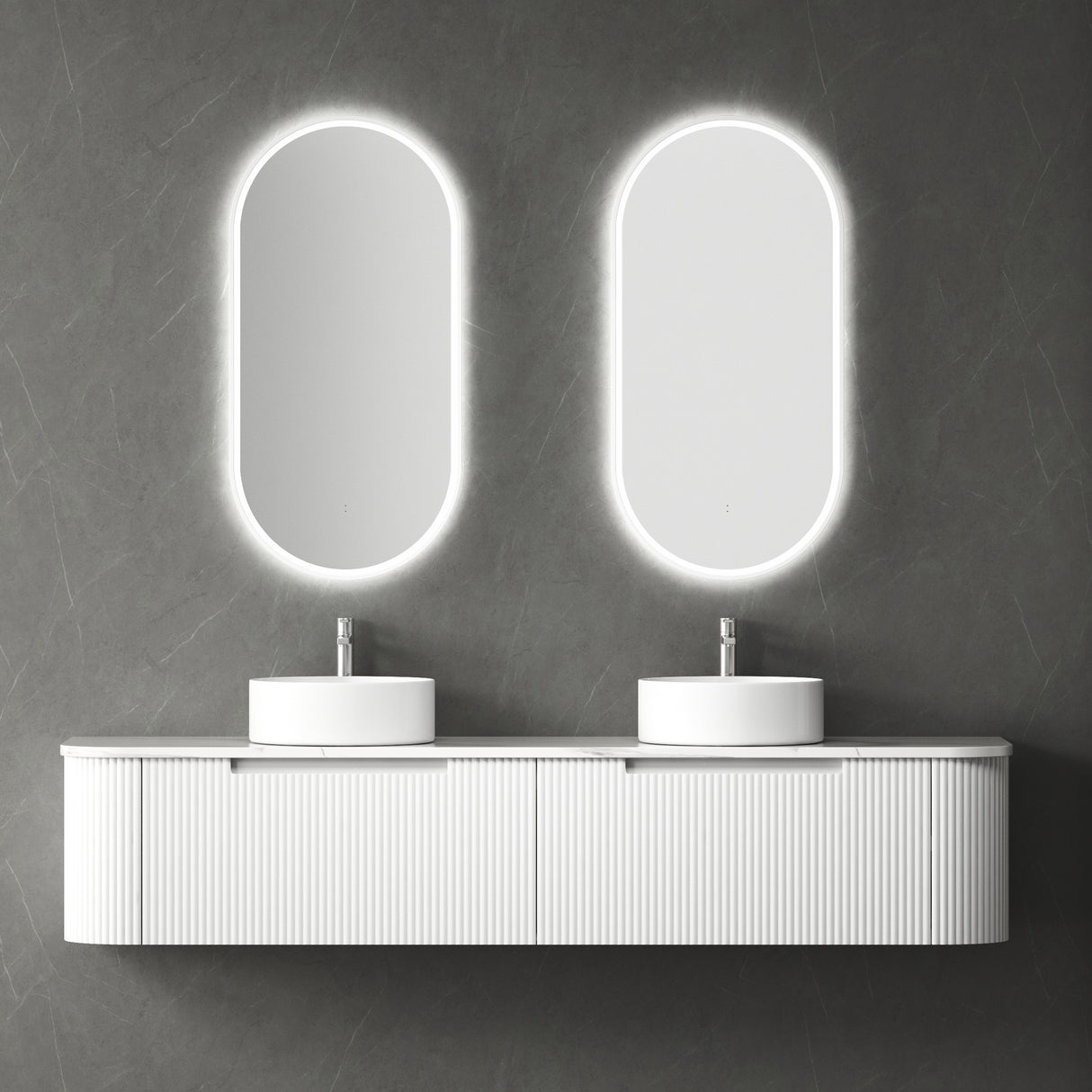 Bathroom vanity with two oval mirrors and white sinks against a gray wall.