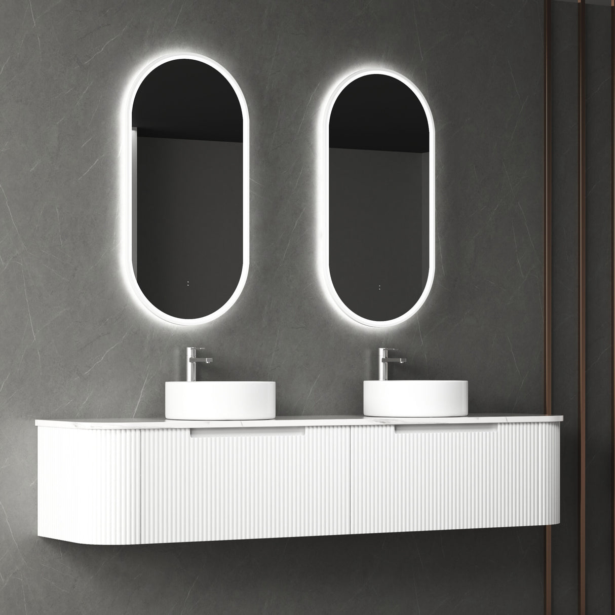 Bathroom vanity with two oval mirrors and lights on a gray wall.