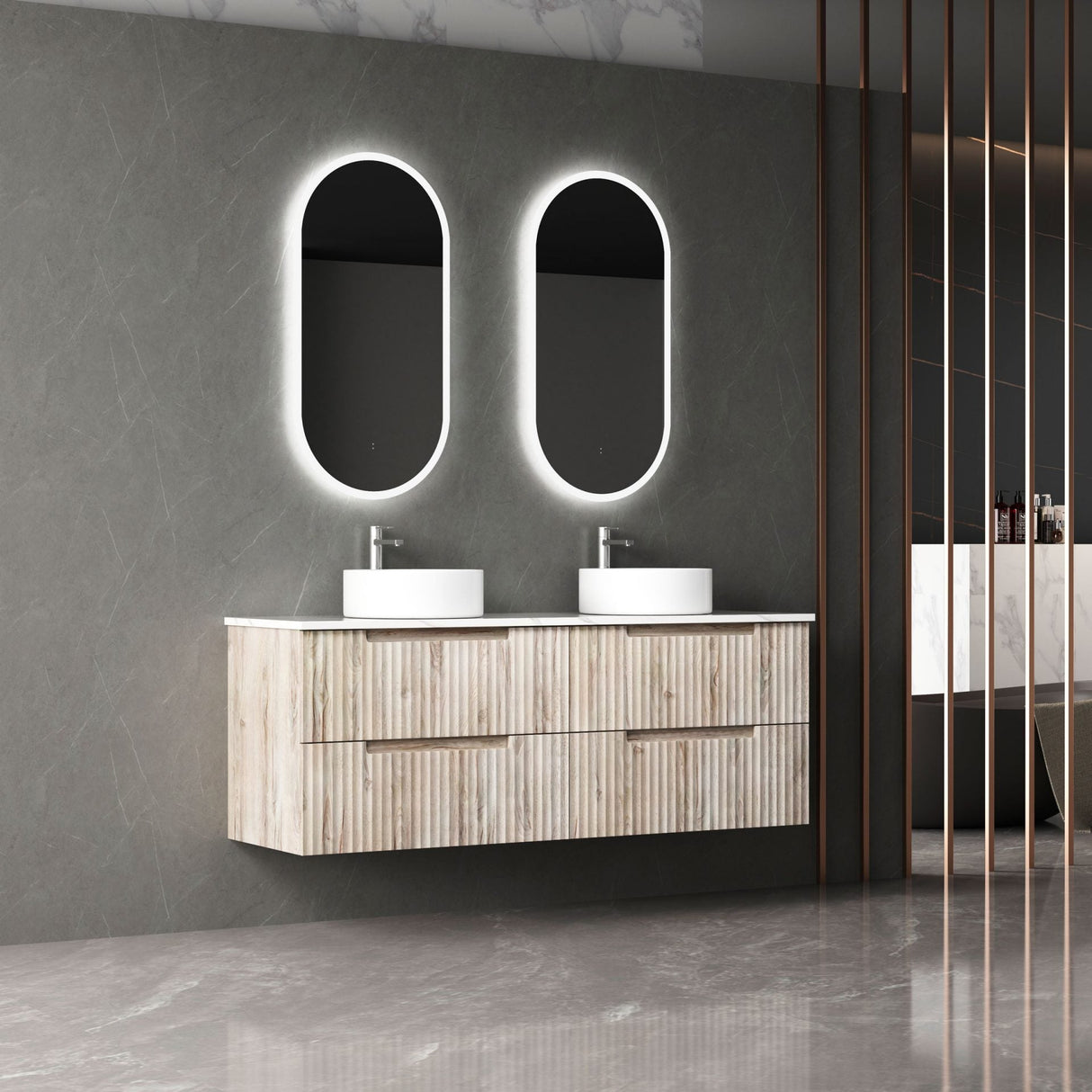 Bathroom vanity with double sink and illuminated mirrors against a gray wall.