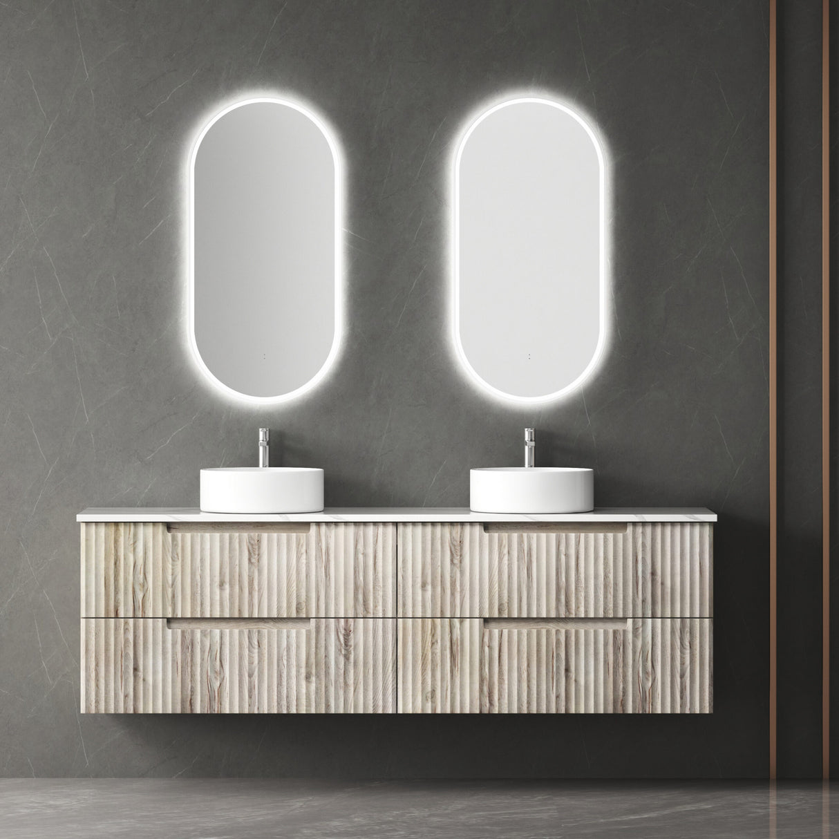 Bathroom vanity with two sinks and illuminated oval mirrors on a gray wall.