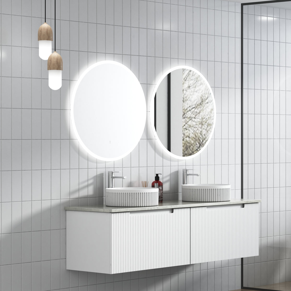Bathroom vanity with round mirrors and light fixtures on a tiled wall.