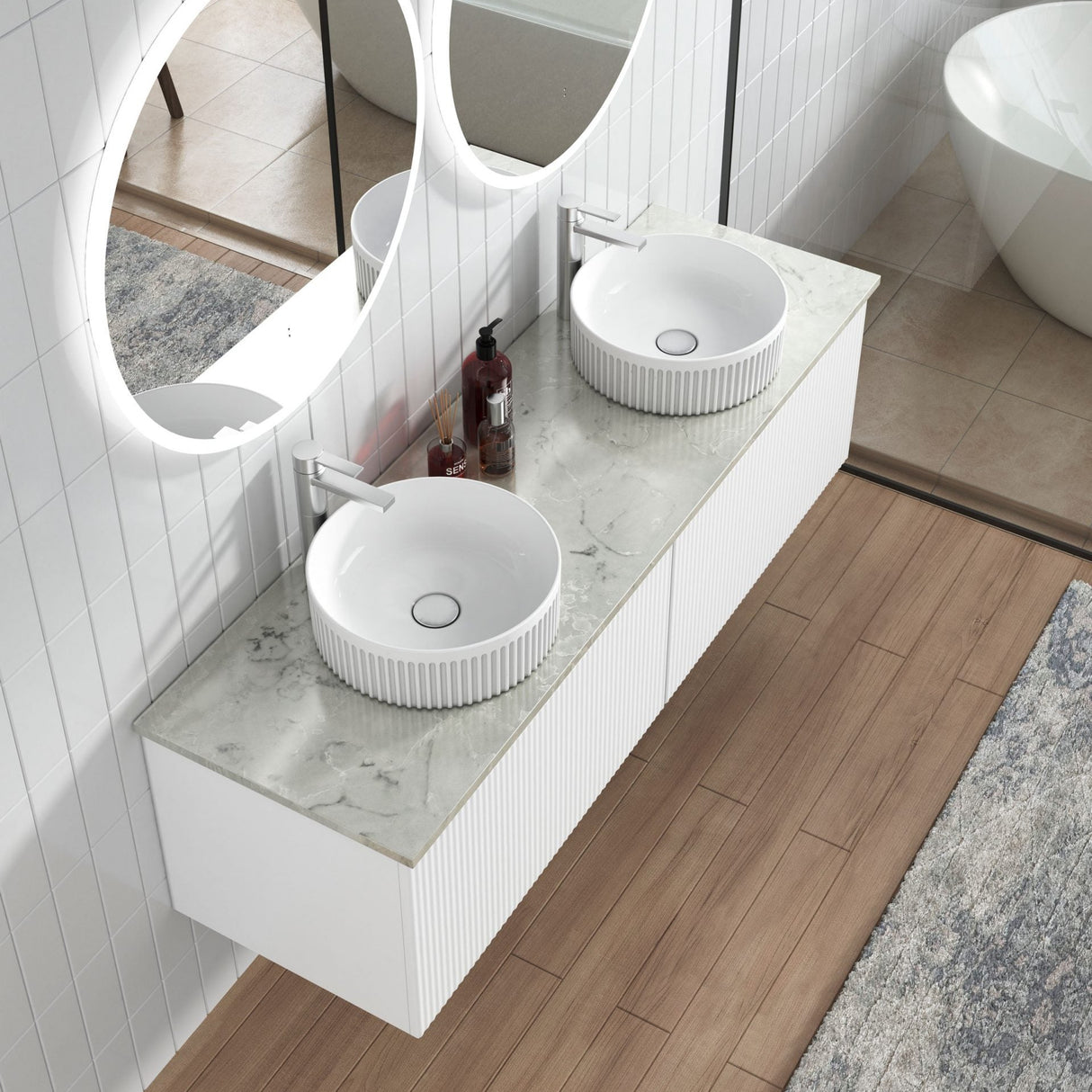Bathroom vanity with two round sinks and a large mirror in a modern bathroom setting.