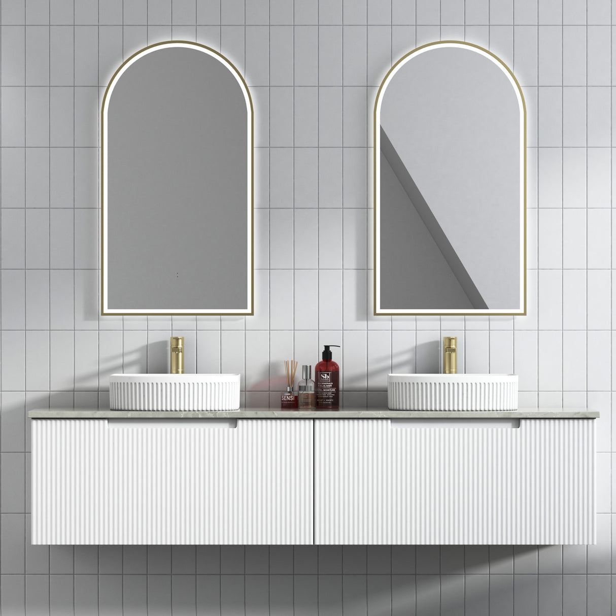 Bathroom vanity with two arched mirrors and a tiled wall.