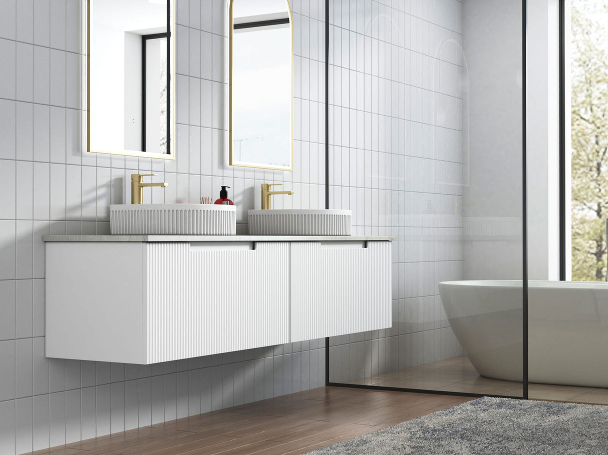 Modern bathroom with white vanity, mirrors, and a bathtub.