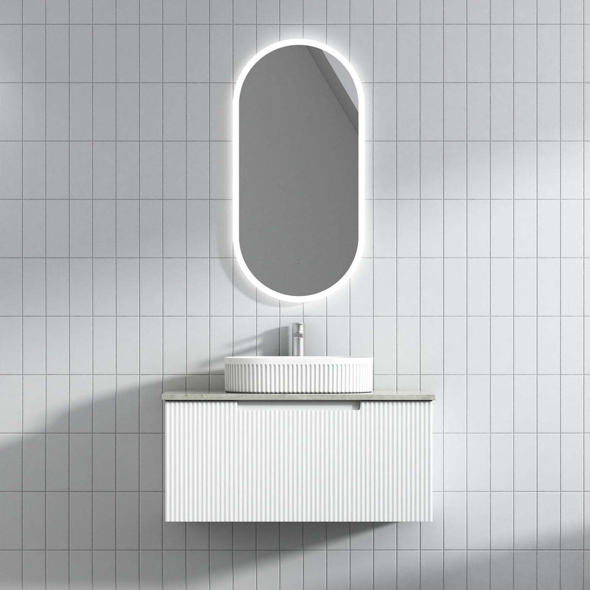 Bathroom vanity with illuminated oval mirror on tiled wall