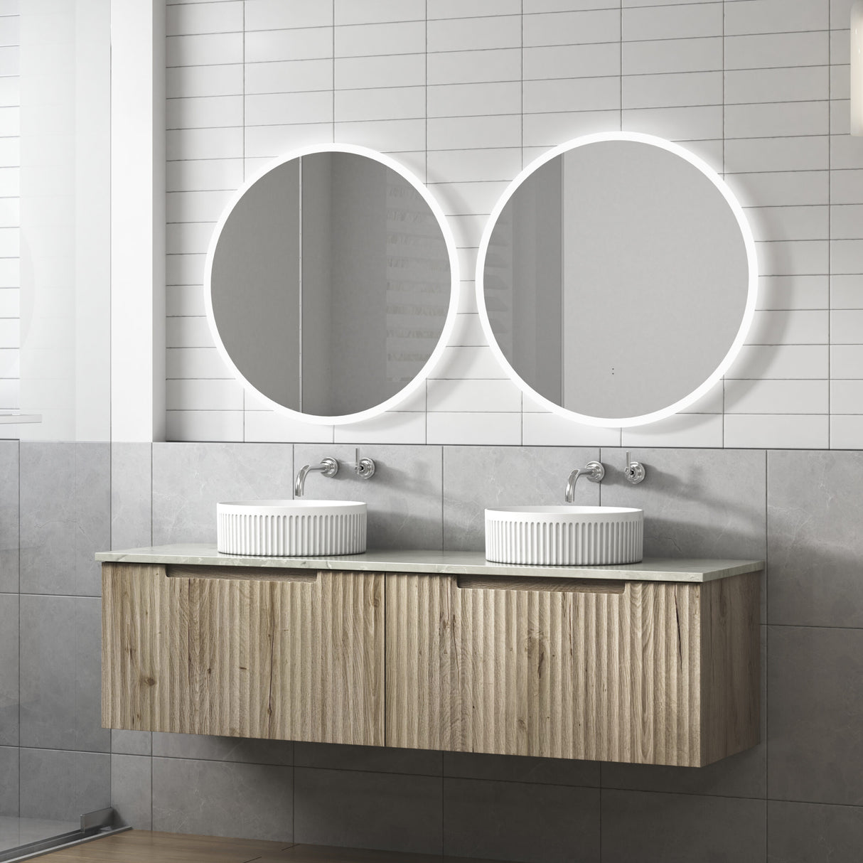Bathroom vanity with two round mirrors and white sinks against a tiled wall.