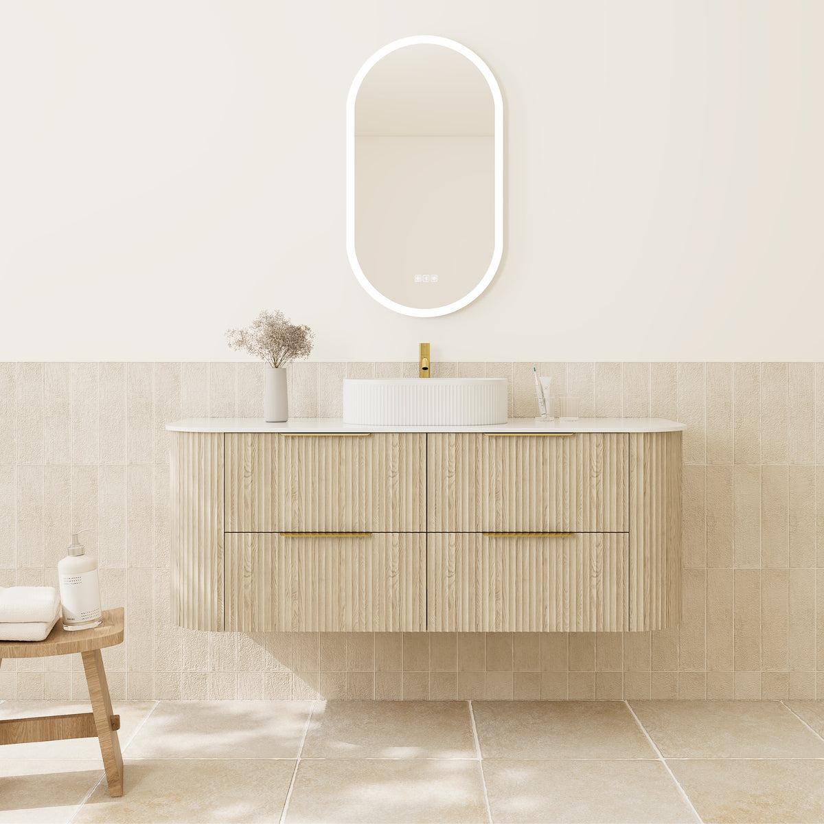 A modern floating bathroom vanity with a ribbed light wood cabinet, white countertop, white vessel sink, and a glowing oval LED mirror mounted on a beige tiled wall.