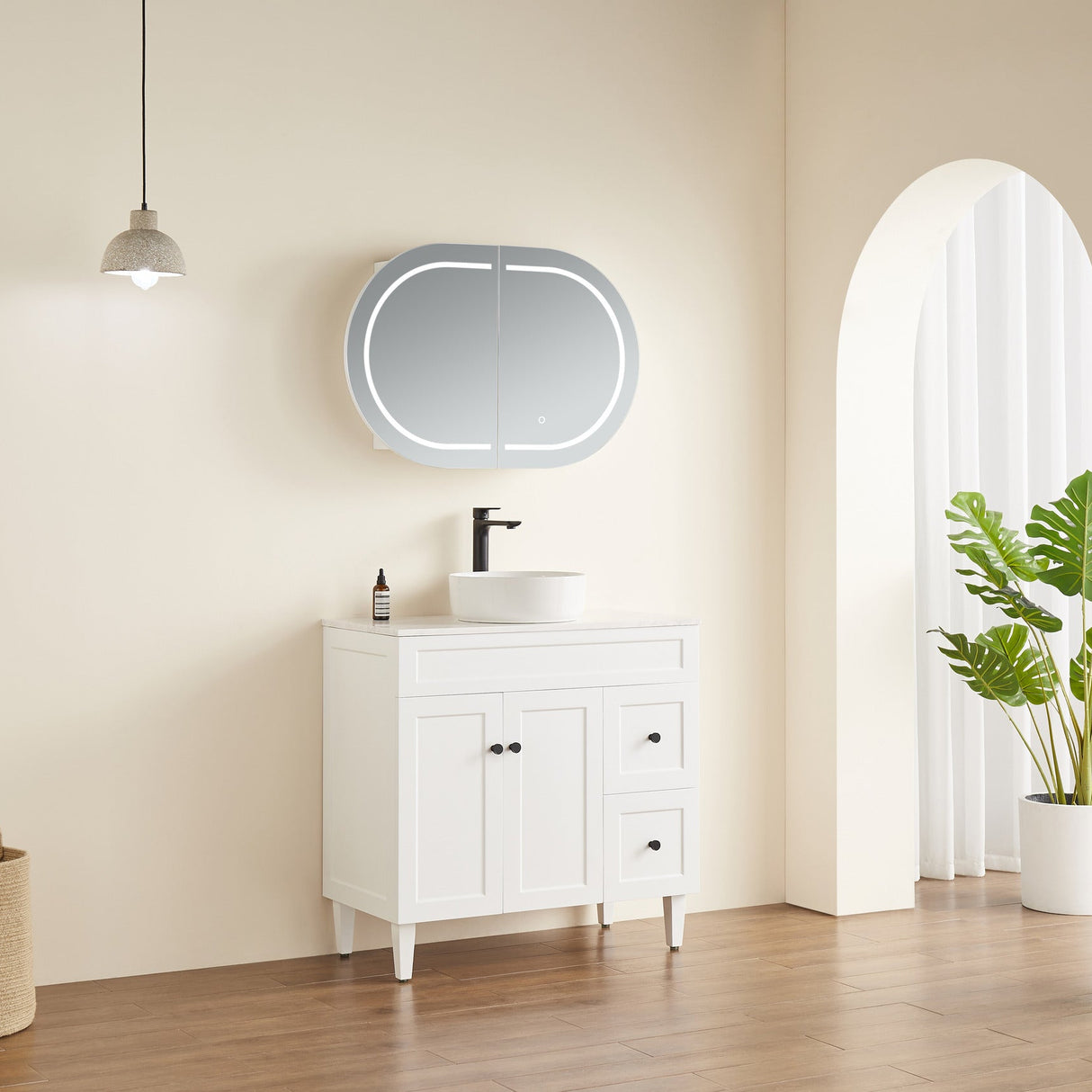 Bathroom with white vanity, round mirror, and plant