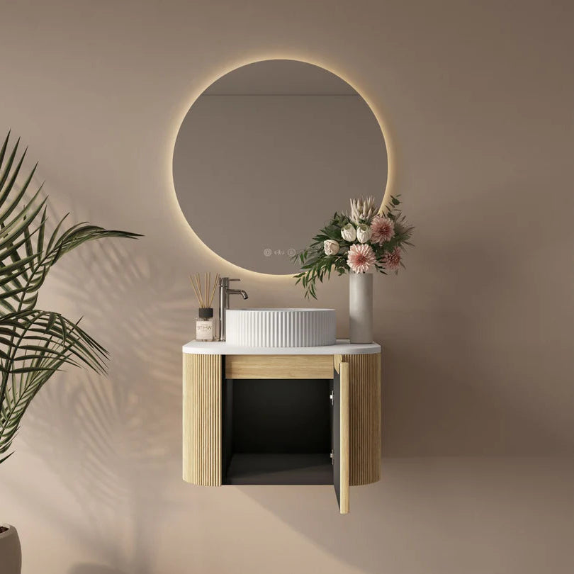 Bathroom vanity with round mirror, sink, and decorative elements on a beige wall.