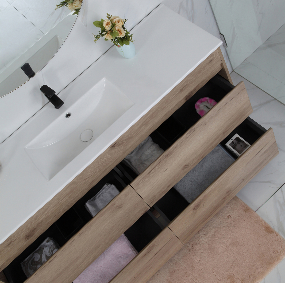 Bathroom vanity with white countertop and wooden drawers, featuring a mirror and decorative elements.