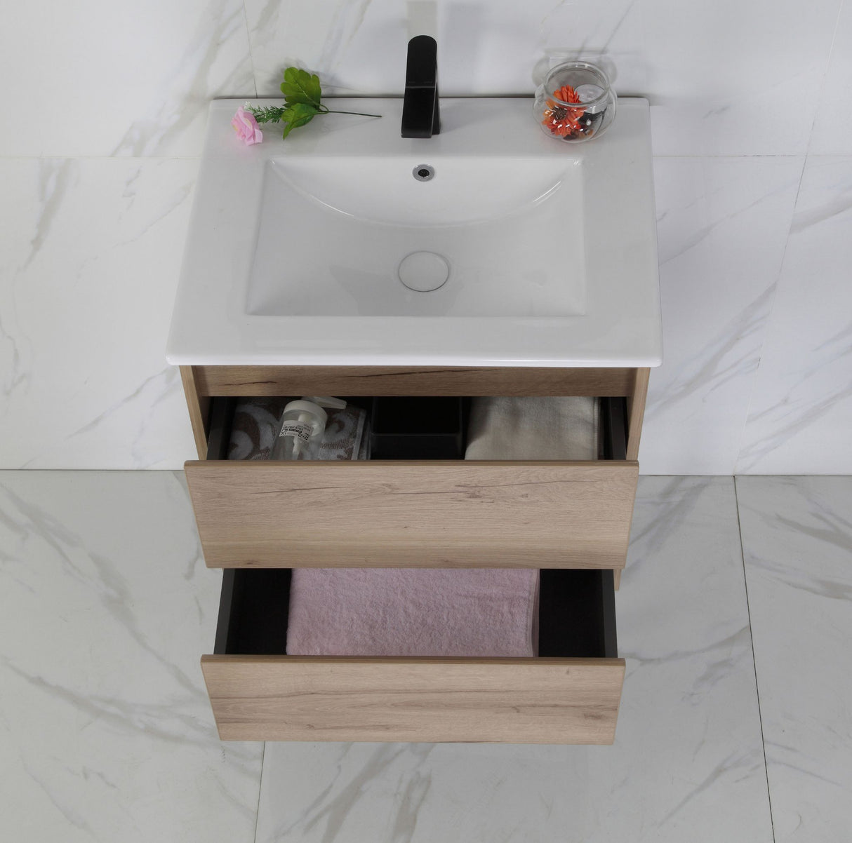 Bathroom vanity with sink and open drawer on a marble floor