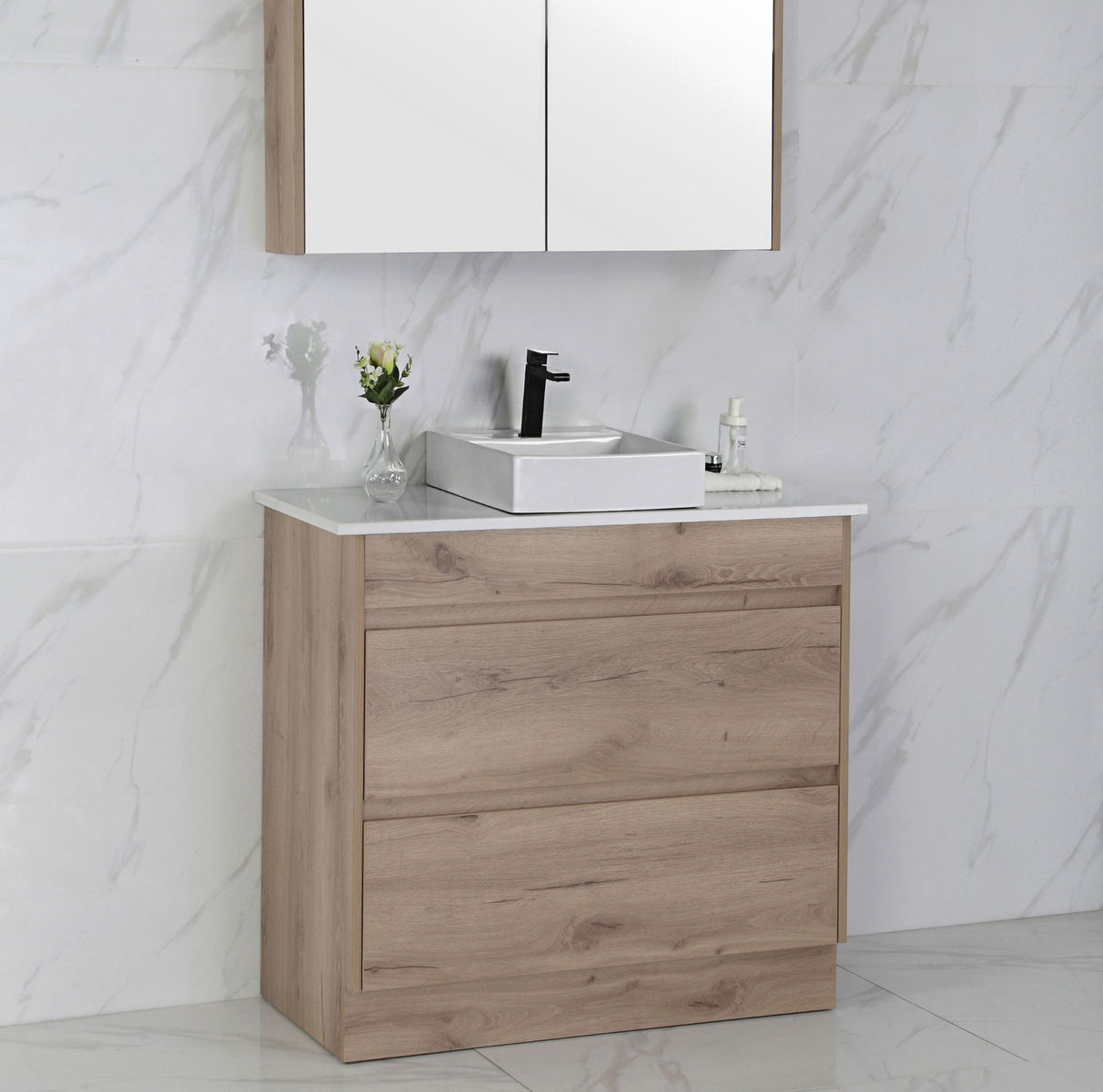 Bathroom vanity with wooden cabinet, white countertop, and mirror on marble wall.