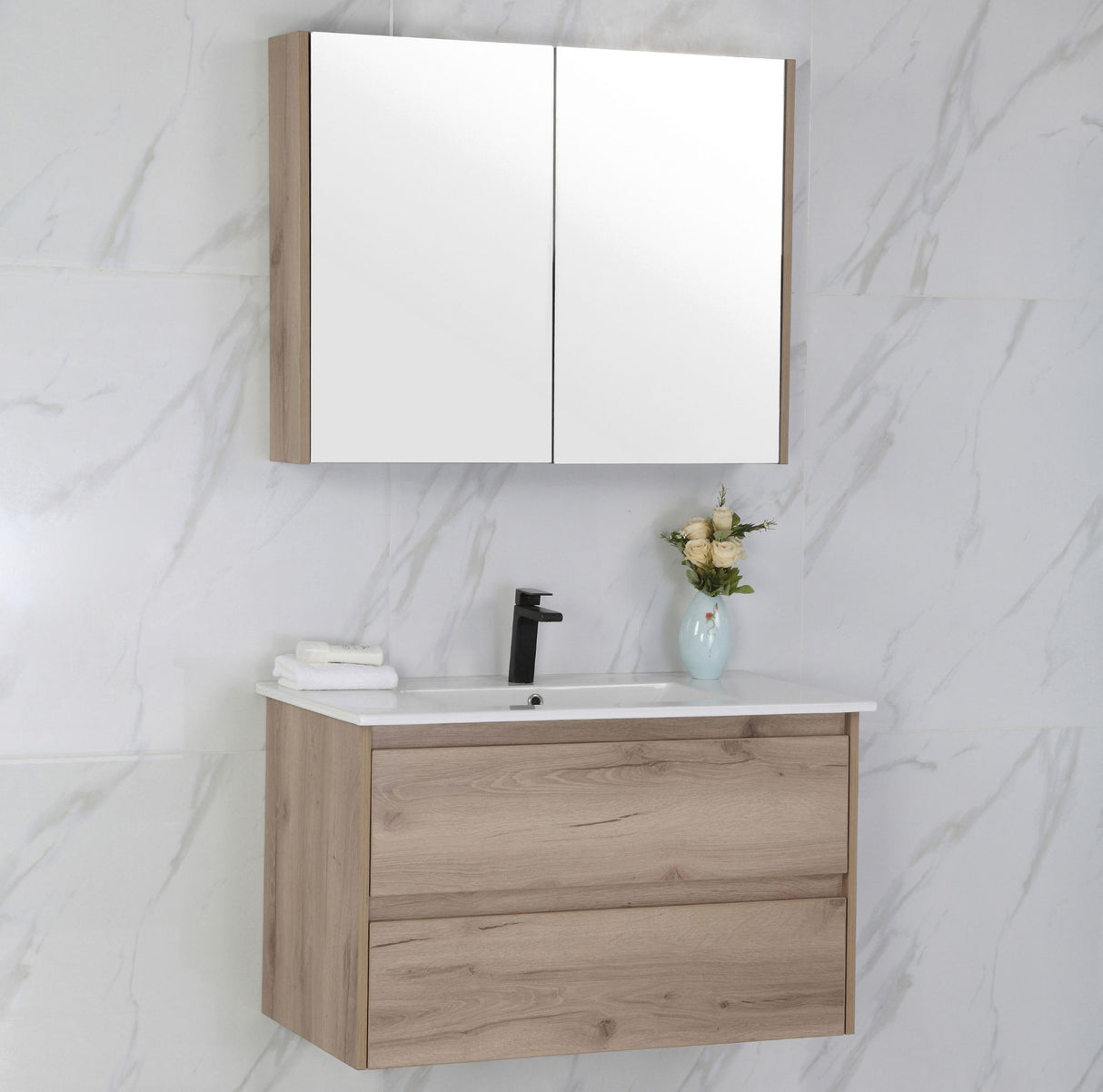 Bathroom vanity with mirror cabinet against a marble wall.