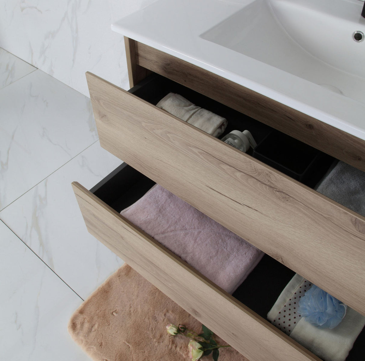 Bathroom drawer with towels and a sink in the background