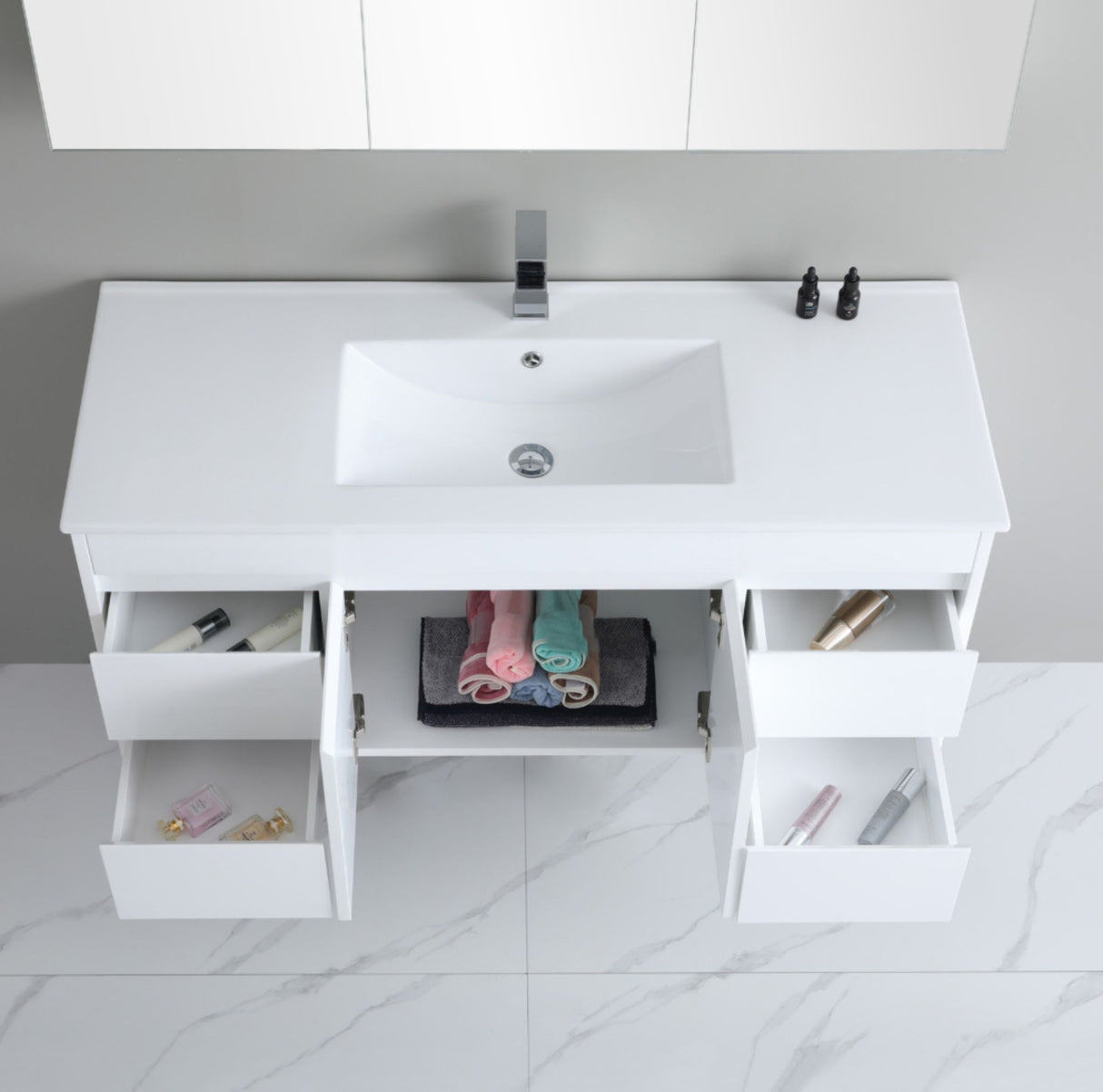 White bathroom vanity with sink and open drawers on a tiled floor.