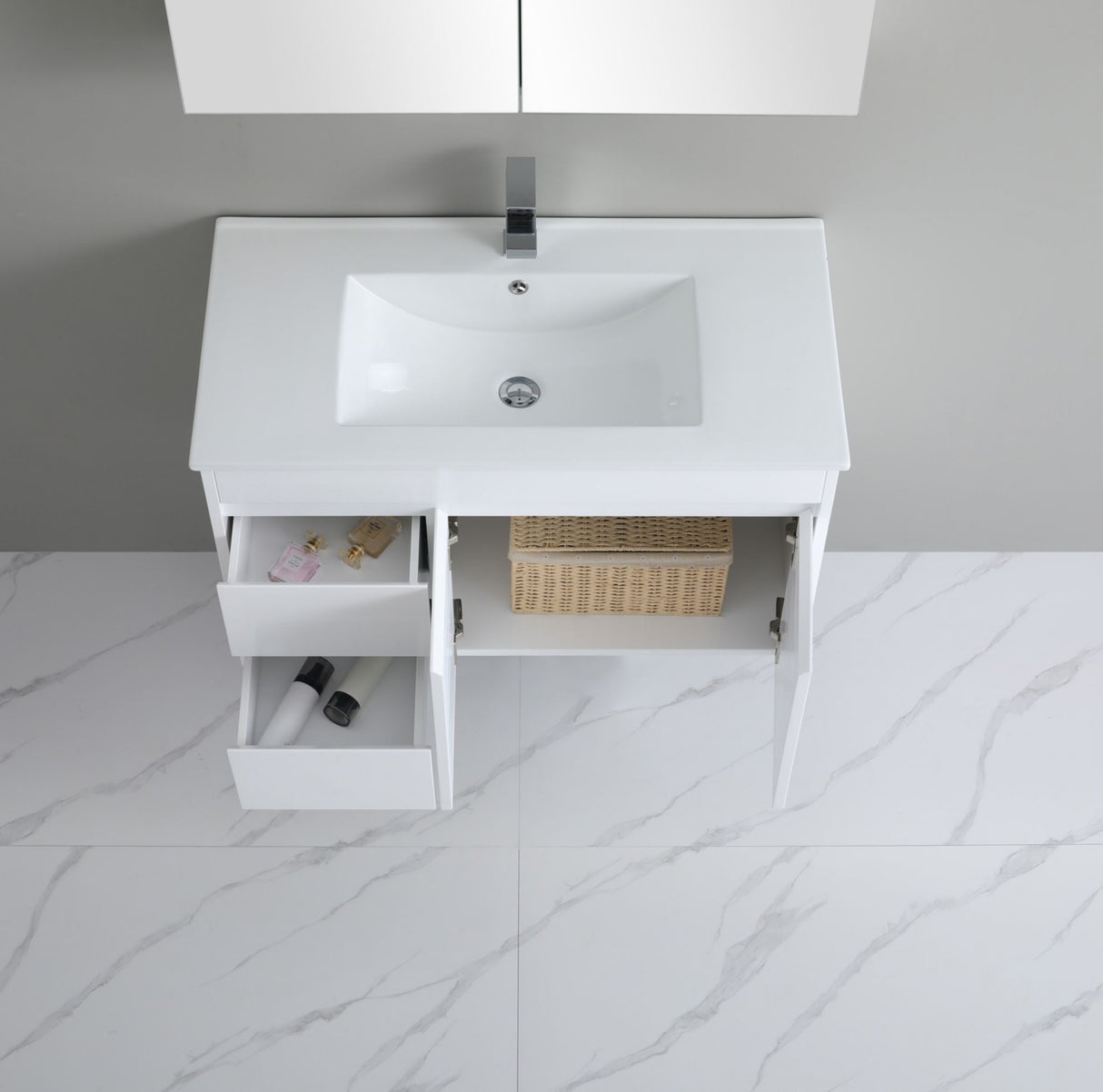 White bathroom vanity with sink and open drawer on a marble floor.