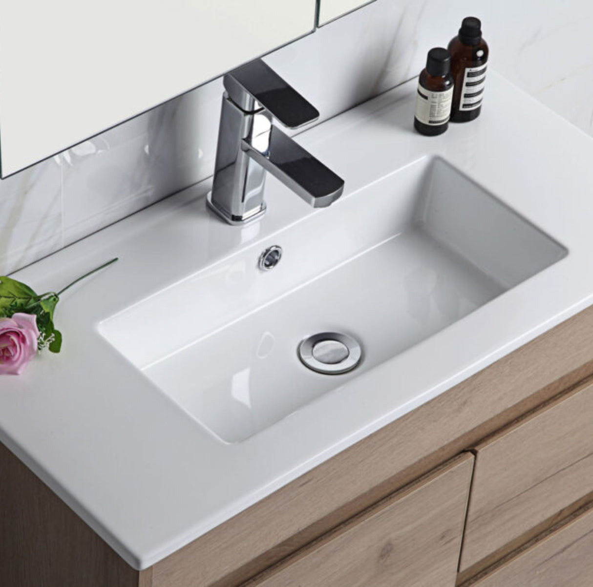 Bathroom vanity with white sink, faucet, and decorative items.
