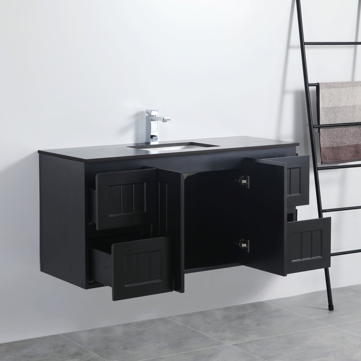 Black bathroom vanity with open cabinet doors in a bathroom setting