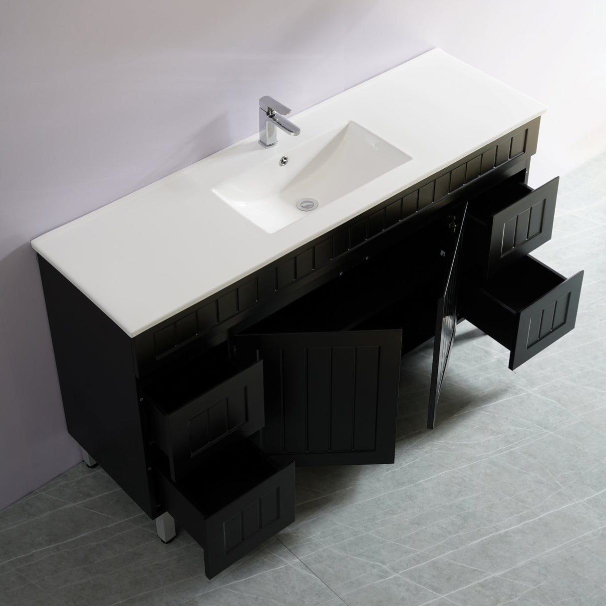 Bathroom vanity with white countertop and black cabinets against a gray wall.