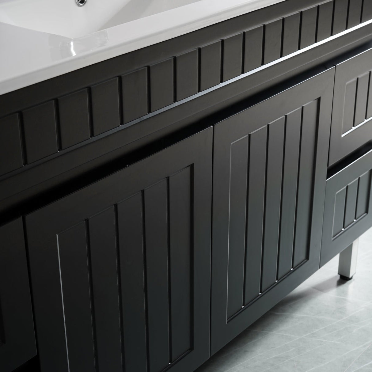 Bathroom vanity with black cabinets and a white countertop.