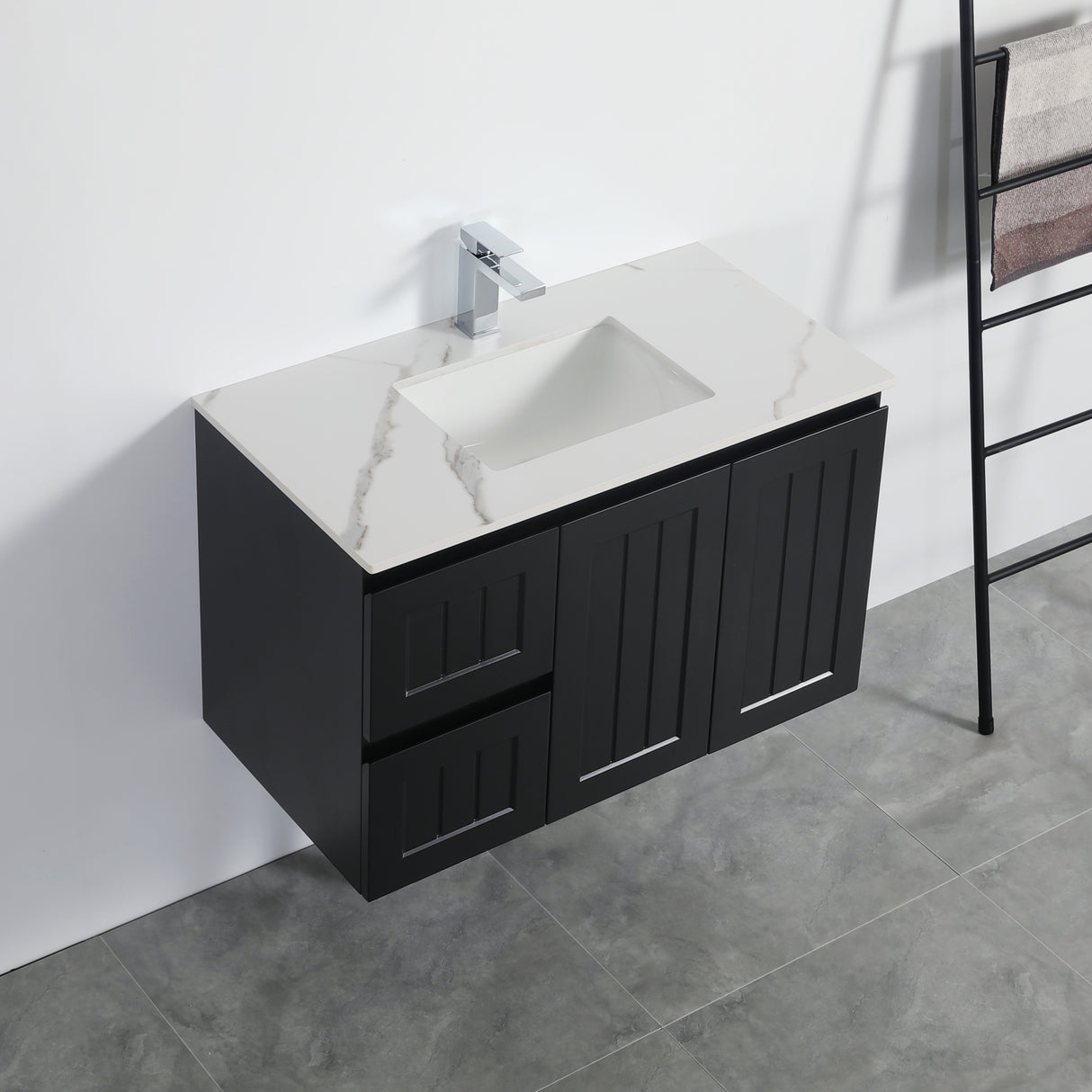 Bathroom vanity with black cabinet and white countertop against a white wall.