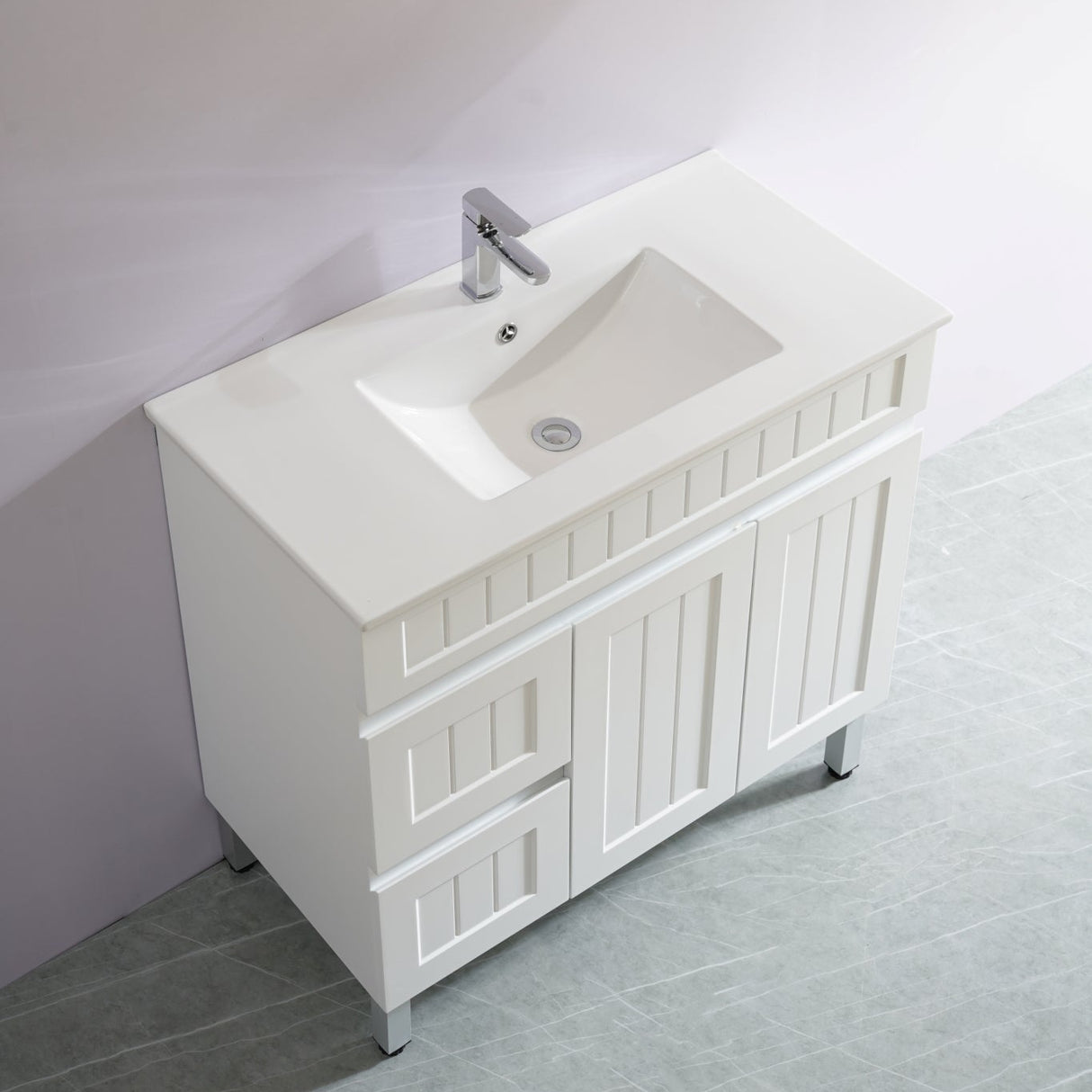 White bathroom vanity with sink against a light gray wall.