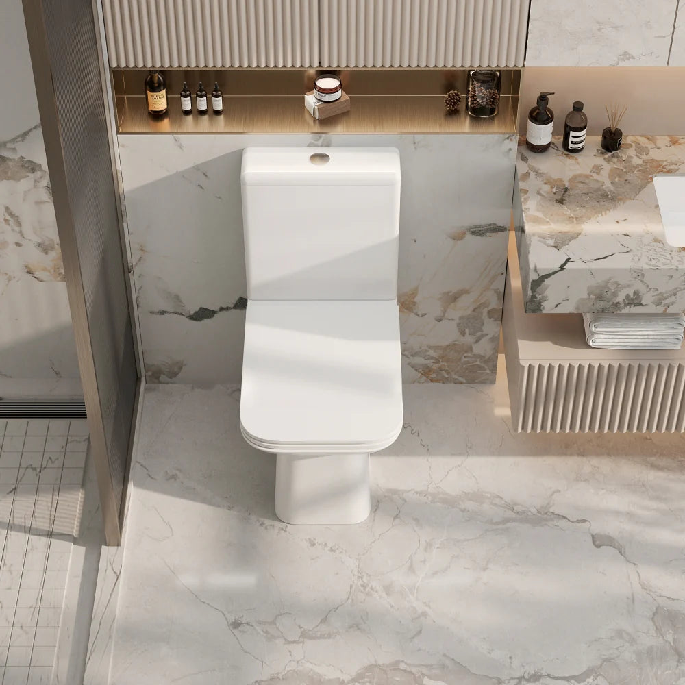 Modern bathroom with a white toilet and marble walls.