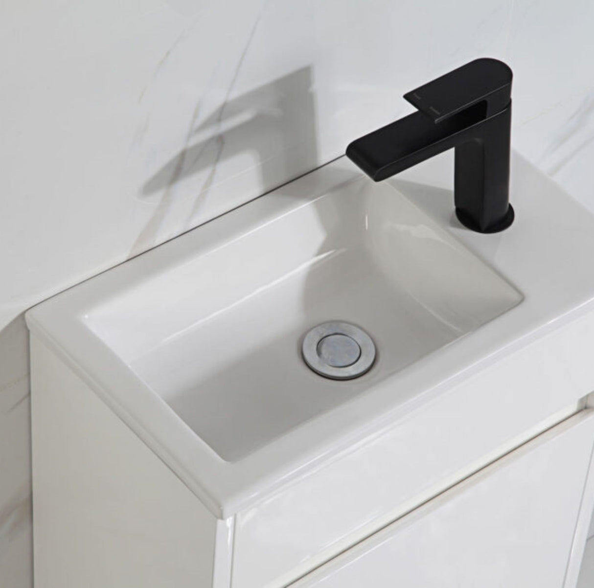 White sink with a black faucet in a bathroom setting