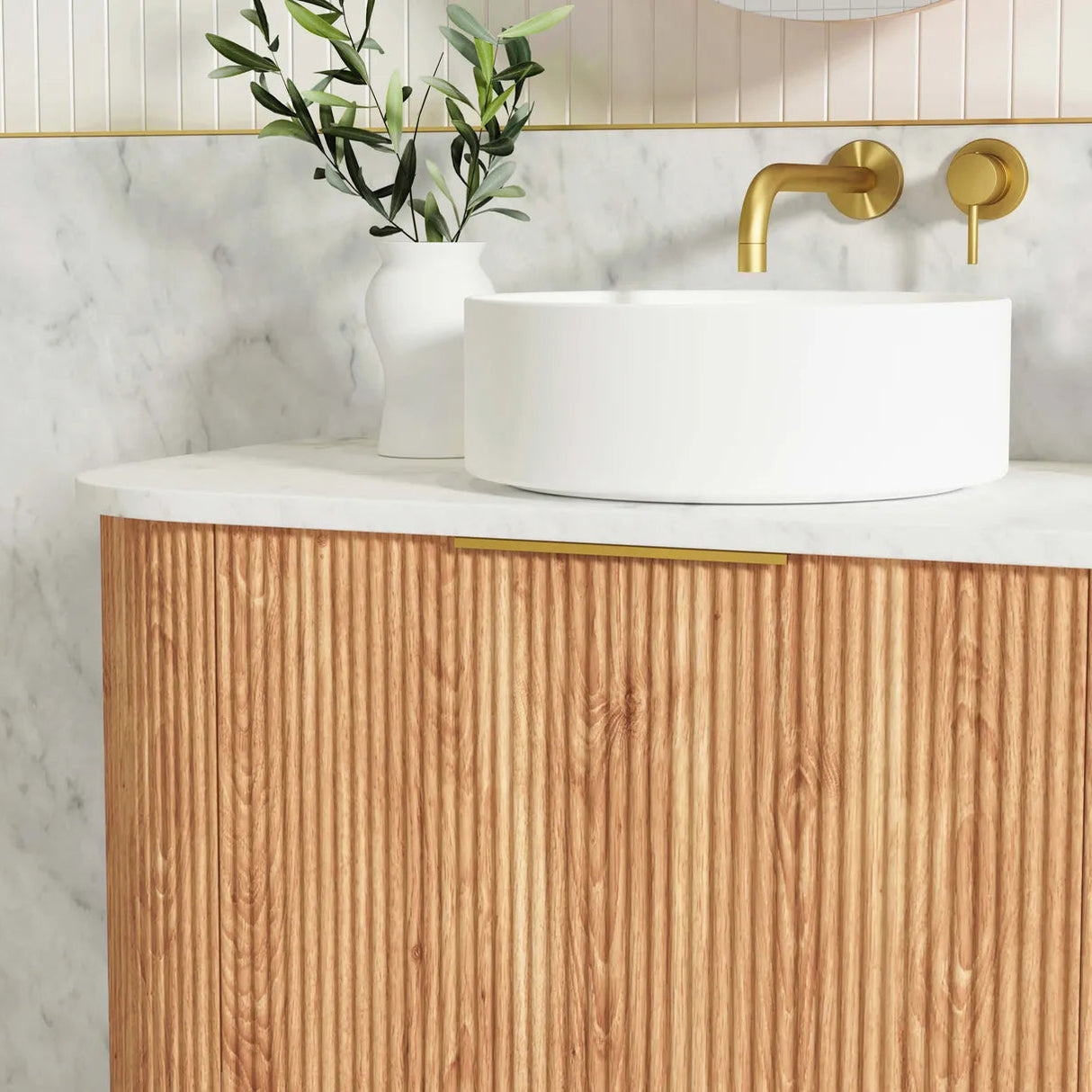 Bathroom vanity with wooden cabinet, white countertop, and gold faucet.