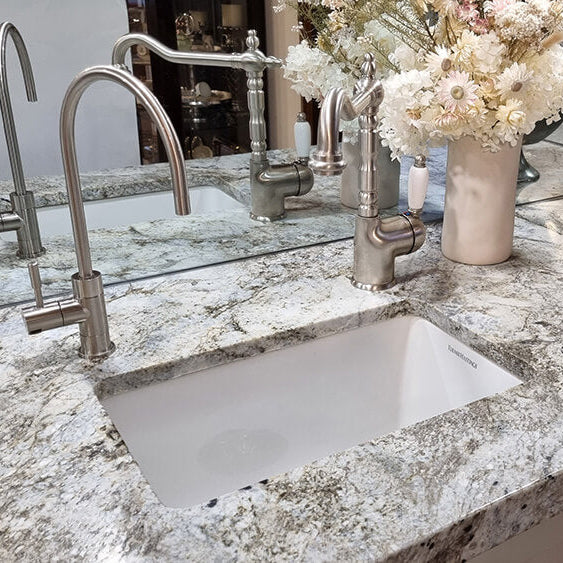 Kitchen countertop with sink, faucet, and decorative elements.