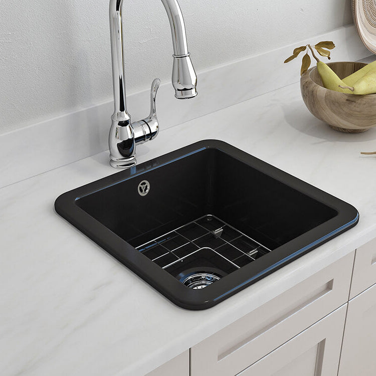 Black kitchen sink with silver faucet on a white countertop