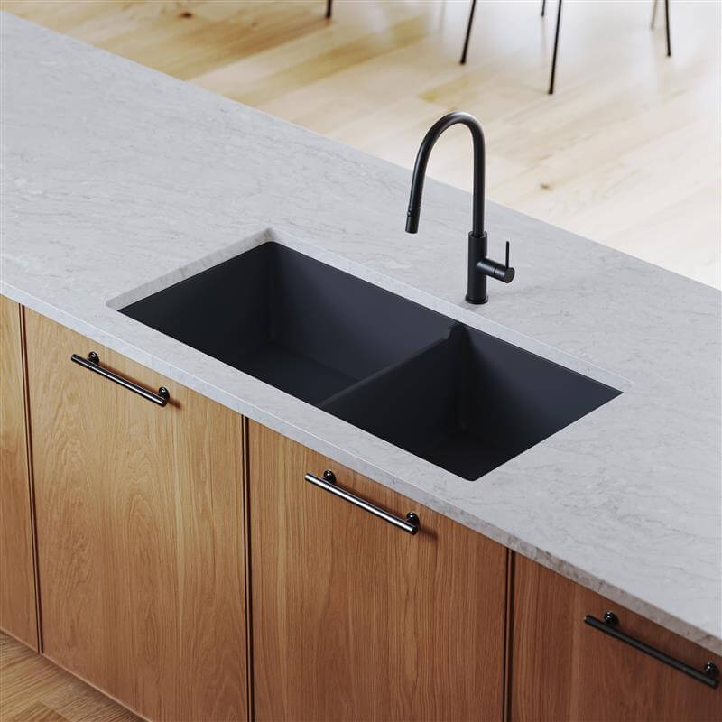 Black kitchen sink with faucet on a light gray countertop in a modern kitchen.