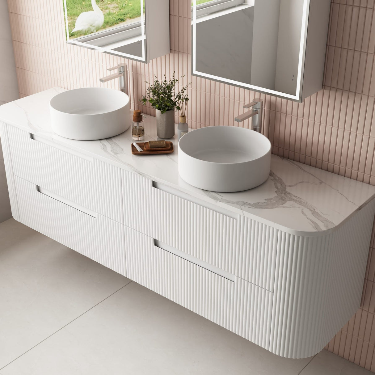 Bathroom vanity with two white sinks and a mirror in a tiled bathroom.