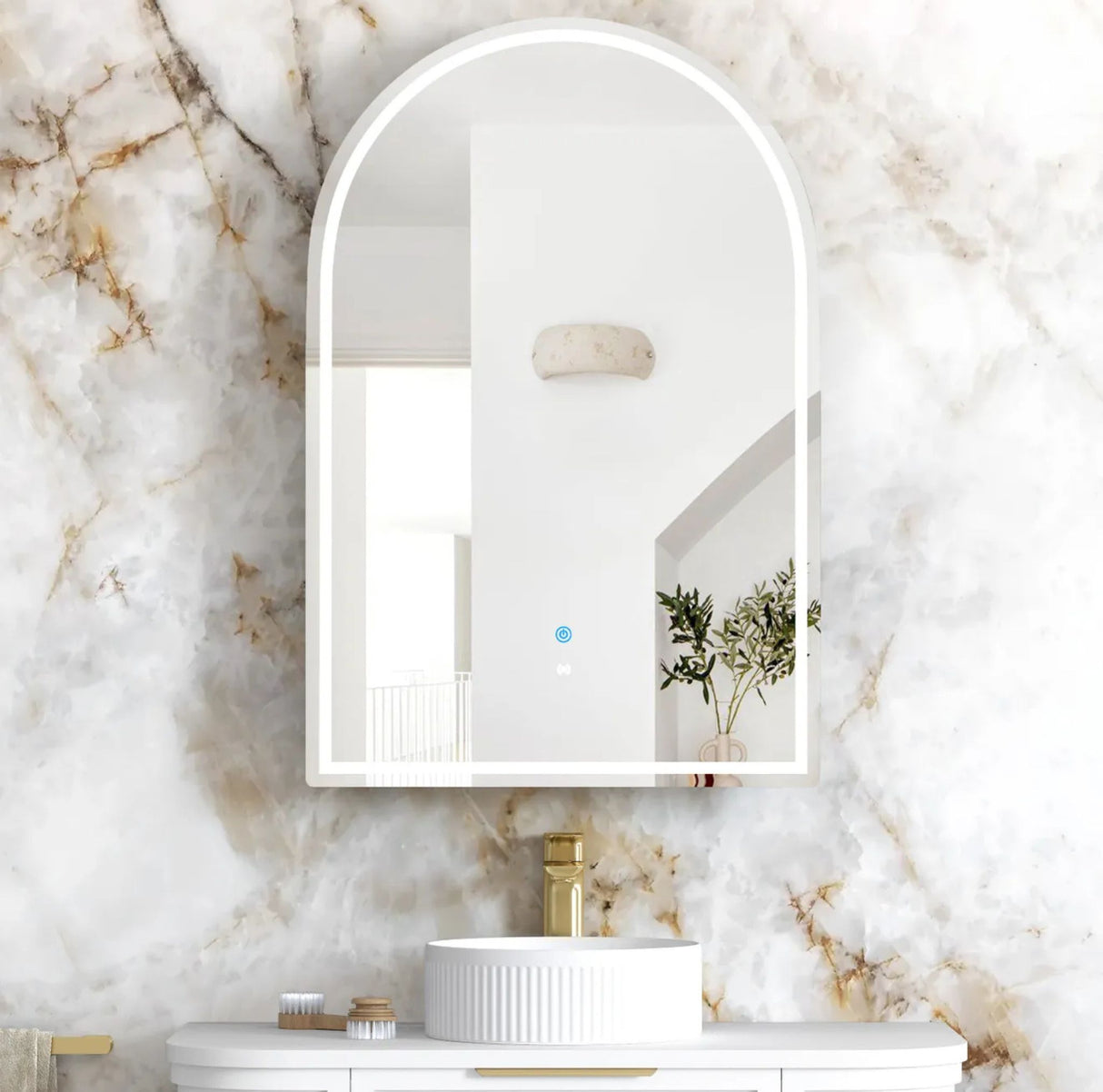 Bathroom with a marble wall, sink, and arch-shaped mirror.