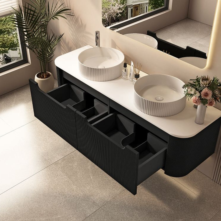 Bathroom vanity with two white sinks and black drawers, featuring a large window and plant.