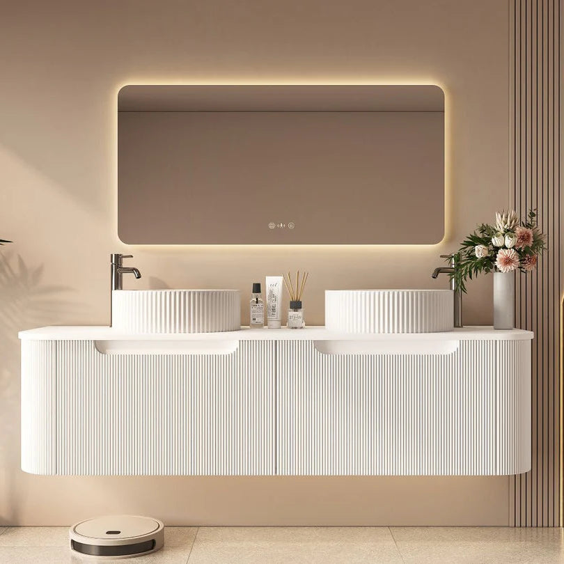 Modern bathroom with a white vanity, illuminated mirror, and decorative elements.