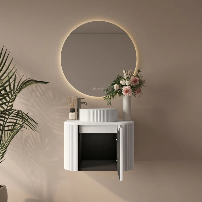 Bathroom setup with a round mirror, sink, and decorative elements on a beige wall.