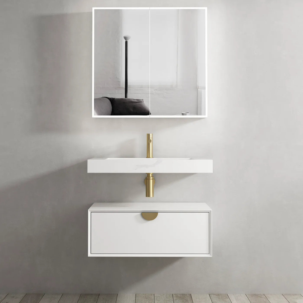 Bathroom vanity with white sink and gold fixtures against a gray wall.