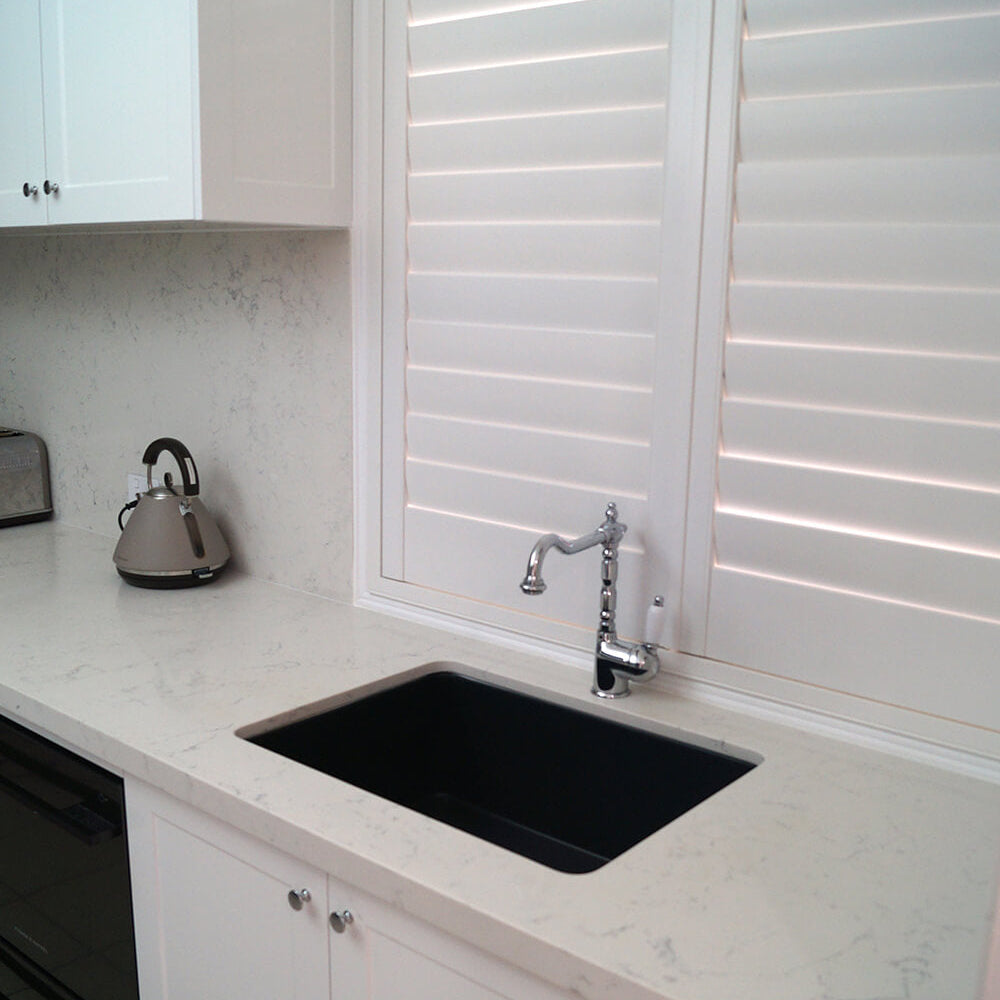 Modern kitchen with black sink and white cabinets