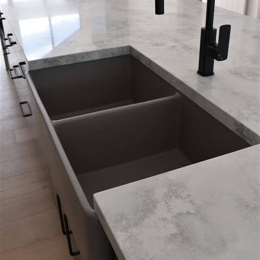 Modern kitchen sink with black faucet on a marble countertop