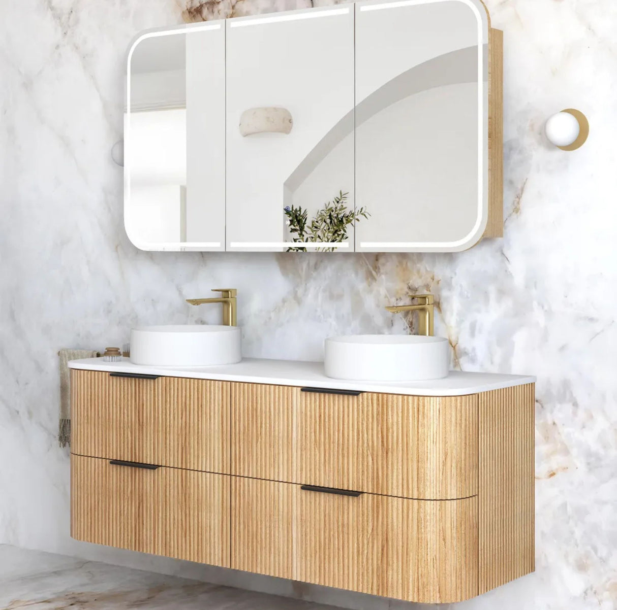 Bathroom vanity with wooden finish and white countertop against a marble wall.