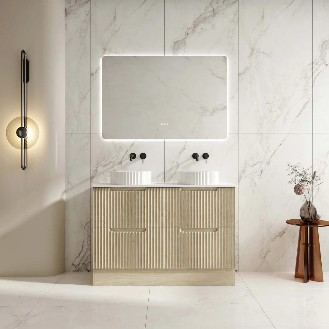 Bathroom vanity with mirror and lighting fixture against a marble wall.
