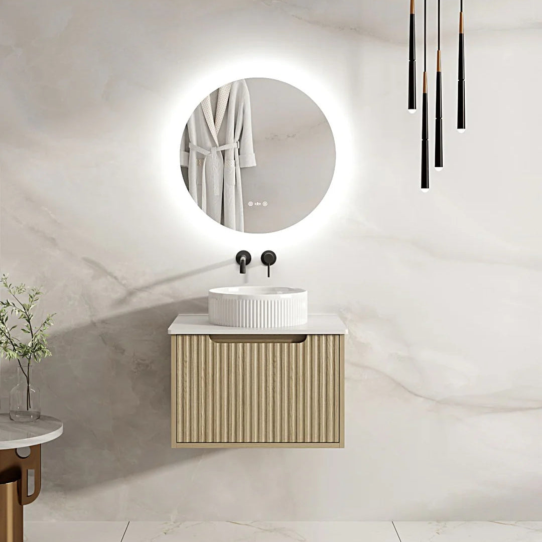 Modern bathroom with a round mirror, sink, and wooden cabinet.