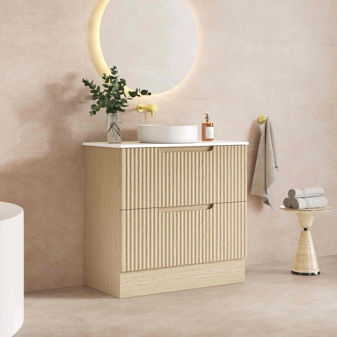 Bathroom vanity with sink, mirror, and decorative items against a beige wall.
