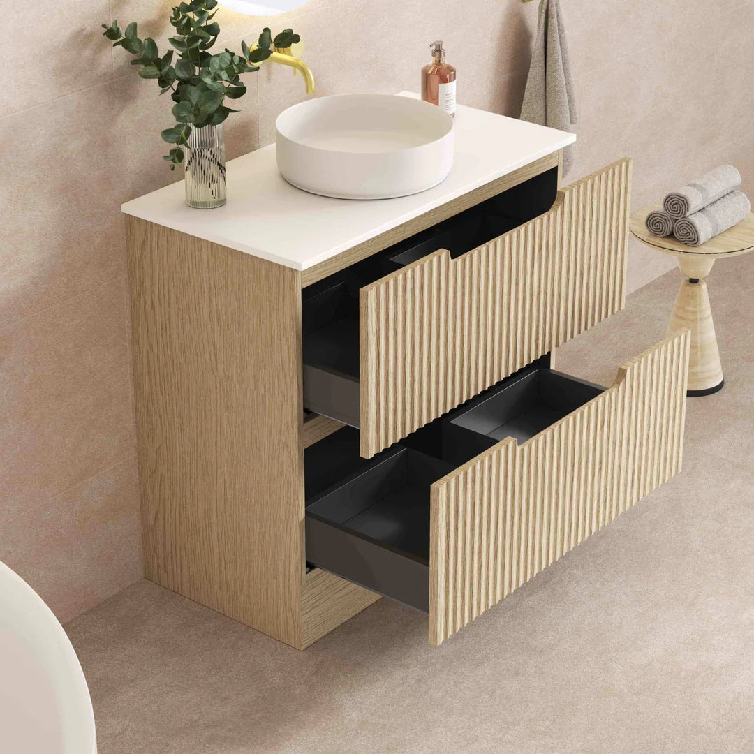 Bathroom vanity with white countertop, round sink, and wooden cabinet with black drawers.