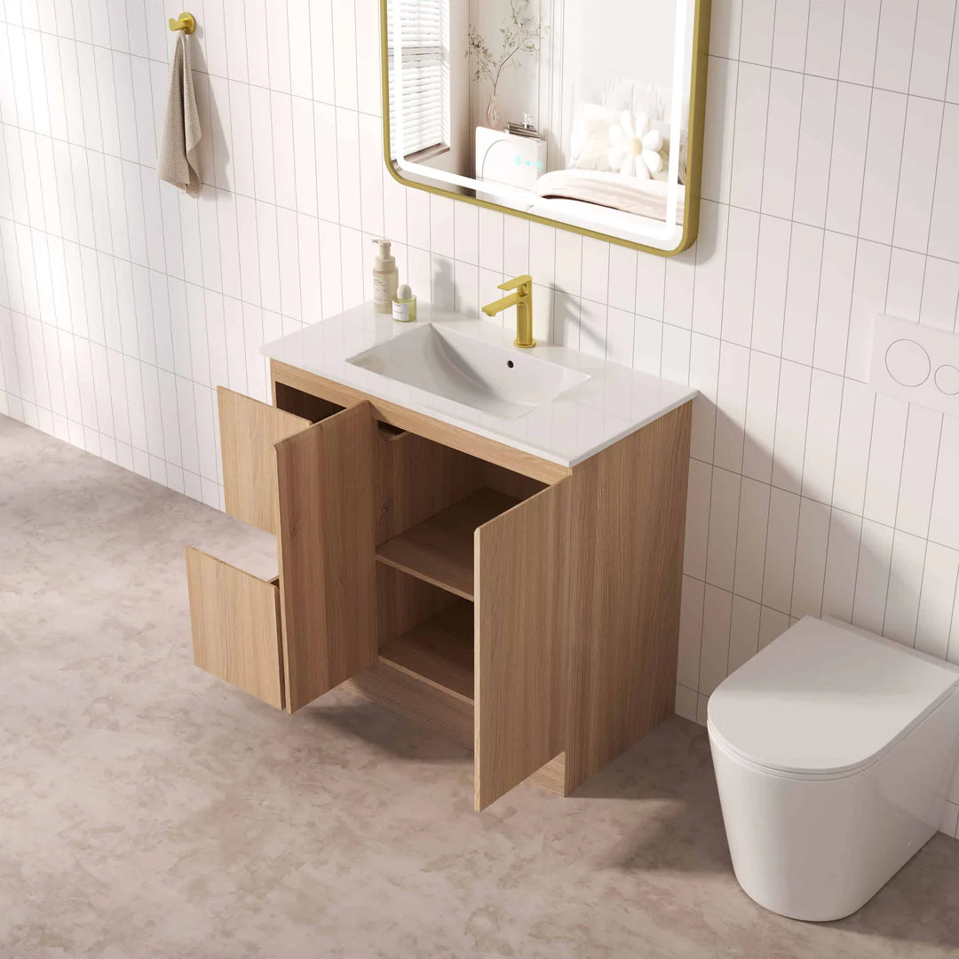 Bathroom setup with wooden vanity, sink, and toilet against a tiled wall.